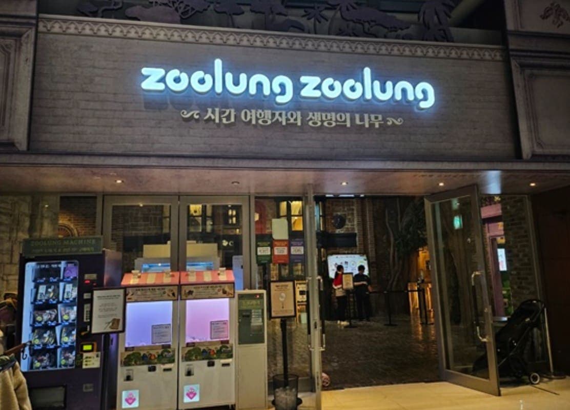 밤에 불을 밝힌 실내 애니멀 테마파크 입구 사이니지