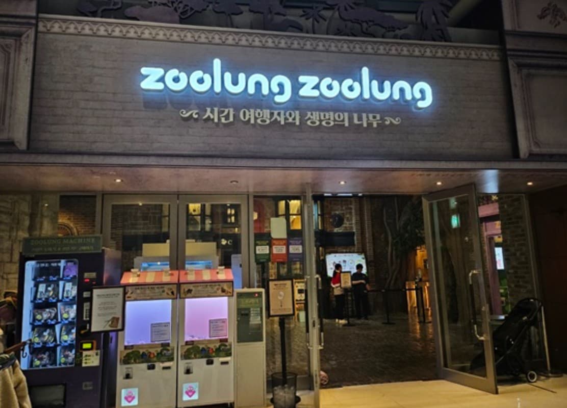 밤에 불을 밝힌 실내 애니멀 테마파크 입구 사이니지