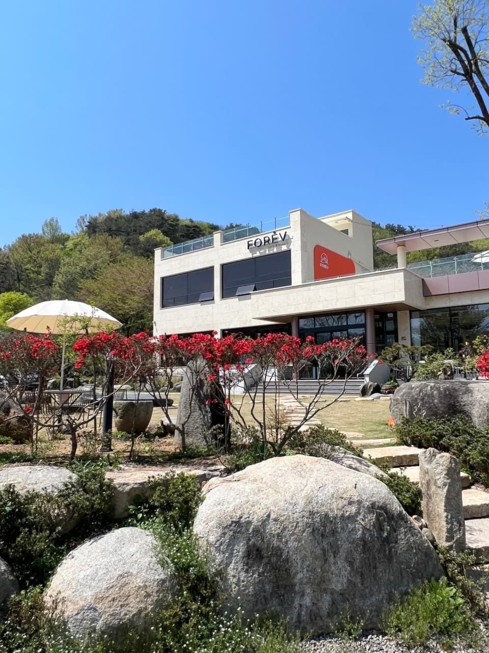 정원과 바위 조경을 갖춘 상사포레브 카페 & 베이커리 건물 전경