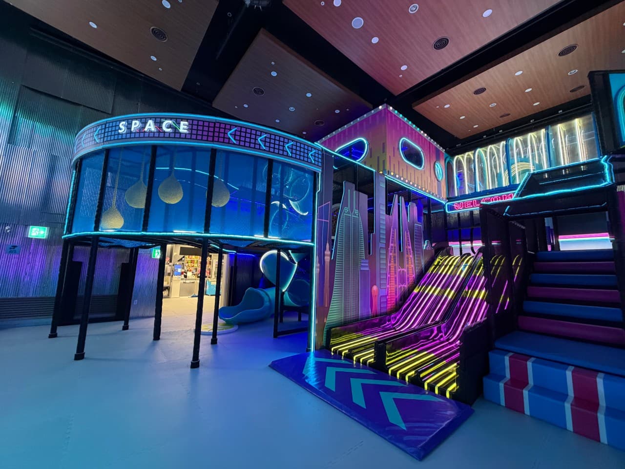네온사인이 흐르는 미래도시 컨셉의 SPACE 존 슬라이드와 정글짐이 늘어선 메타시티 중동점 놀이 공간